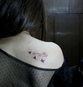 女生肩背英文字母与小鸟纹身图案