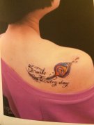 一款女性彩色肩部羽毛字母纹身图案由武汉纹身网推荐